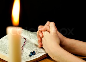 1916724-760415-open-bible-with-burning-candle-and-hands-of-praying-woman